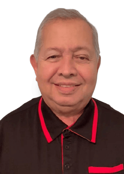 Elderly man smiling, wearing a black shirt with red accents on the collar and sleeves.